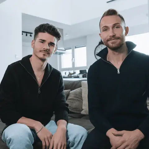 Die 2 Gründer Nico & Marco sitzen auf dem Sofa und lachen in die Kamera