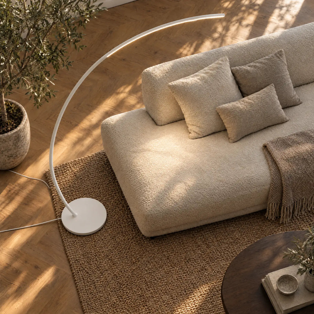 Aluna Bogenleuchte in Weiß von oben über einem Sofa